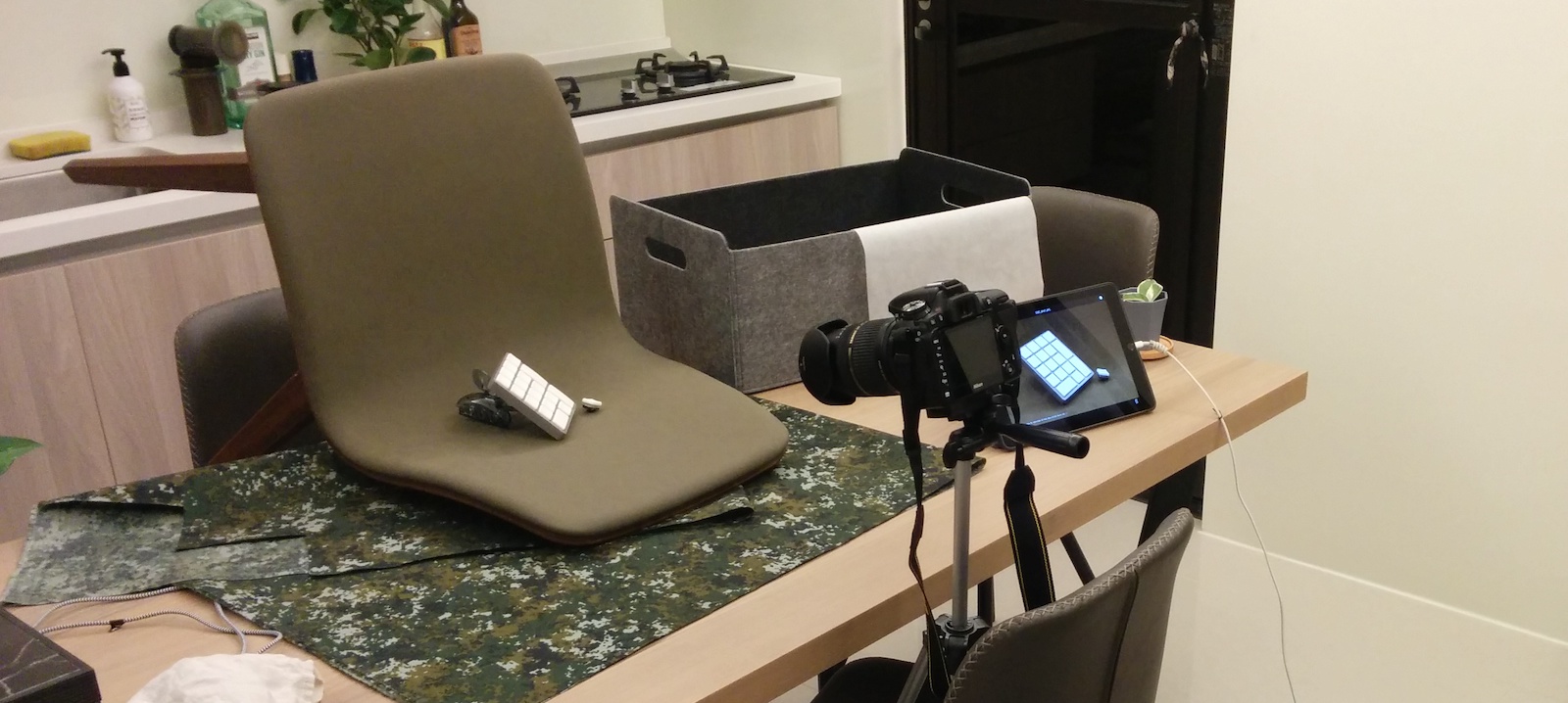 A keyboard being photographed in a chair on a kitchen table