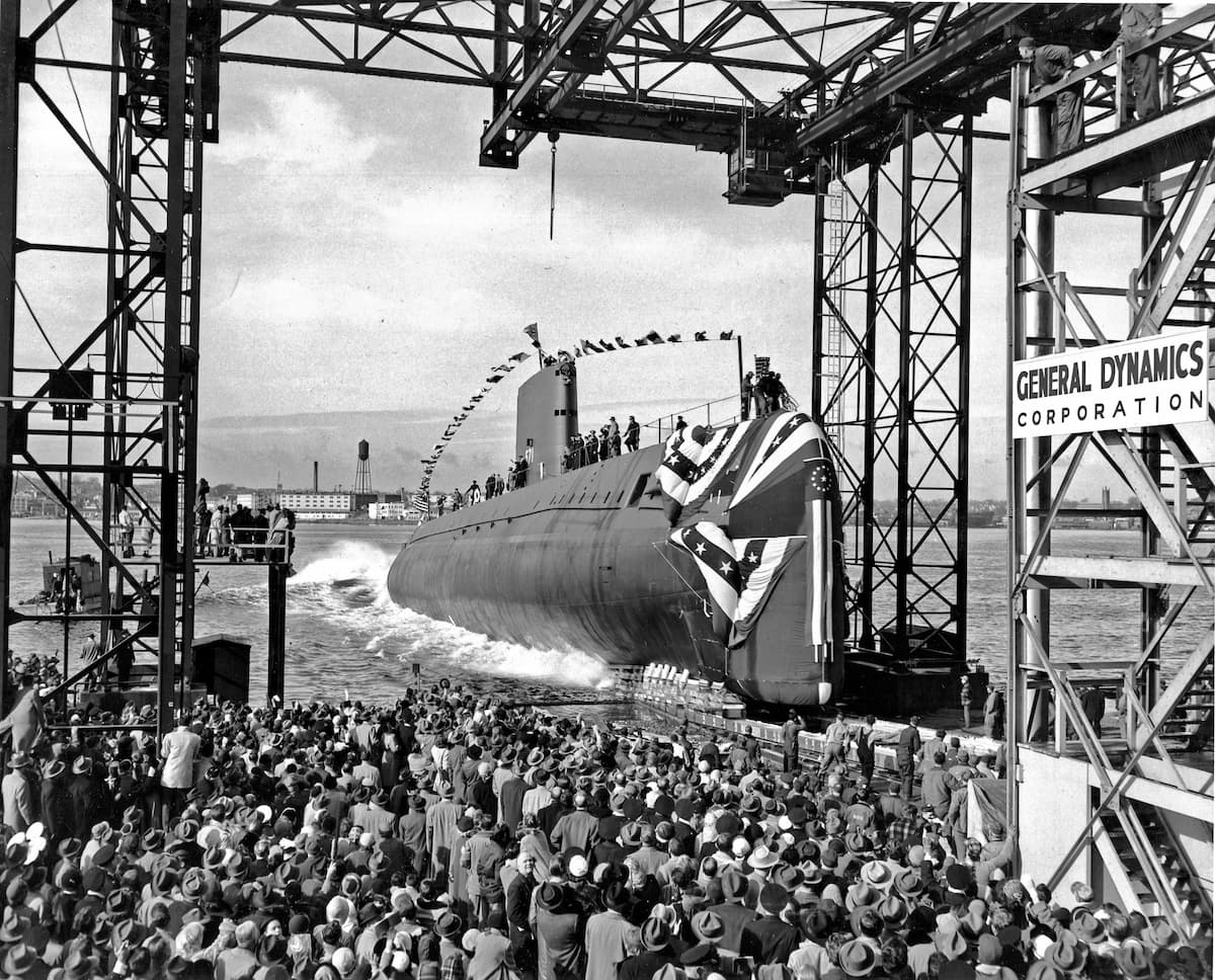 A bunch of people watching the first nuclear submarine entering the water