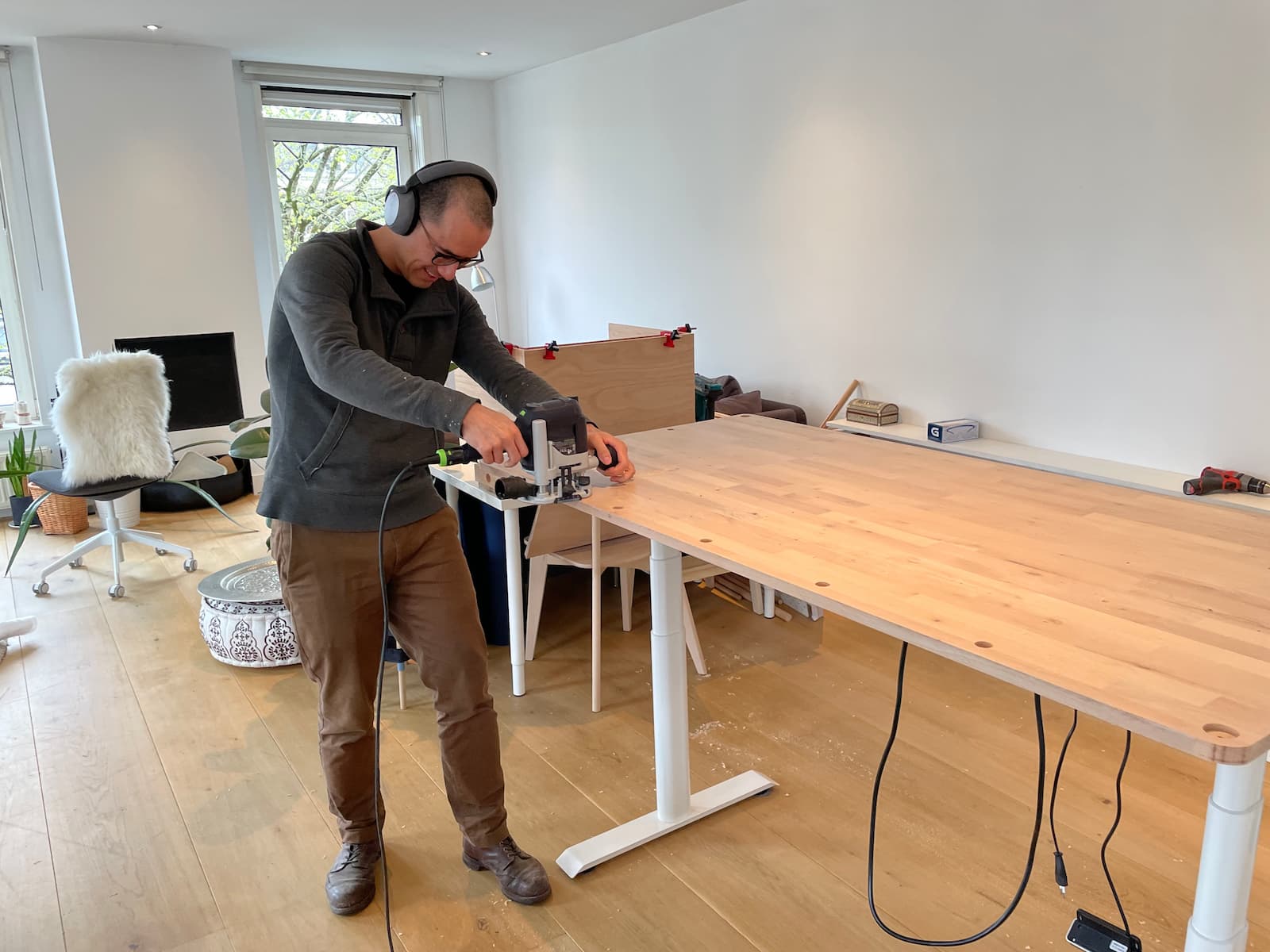 Kevin breaking edges on his standing desk top with a hand router