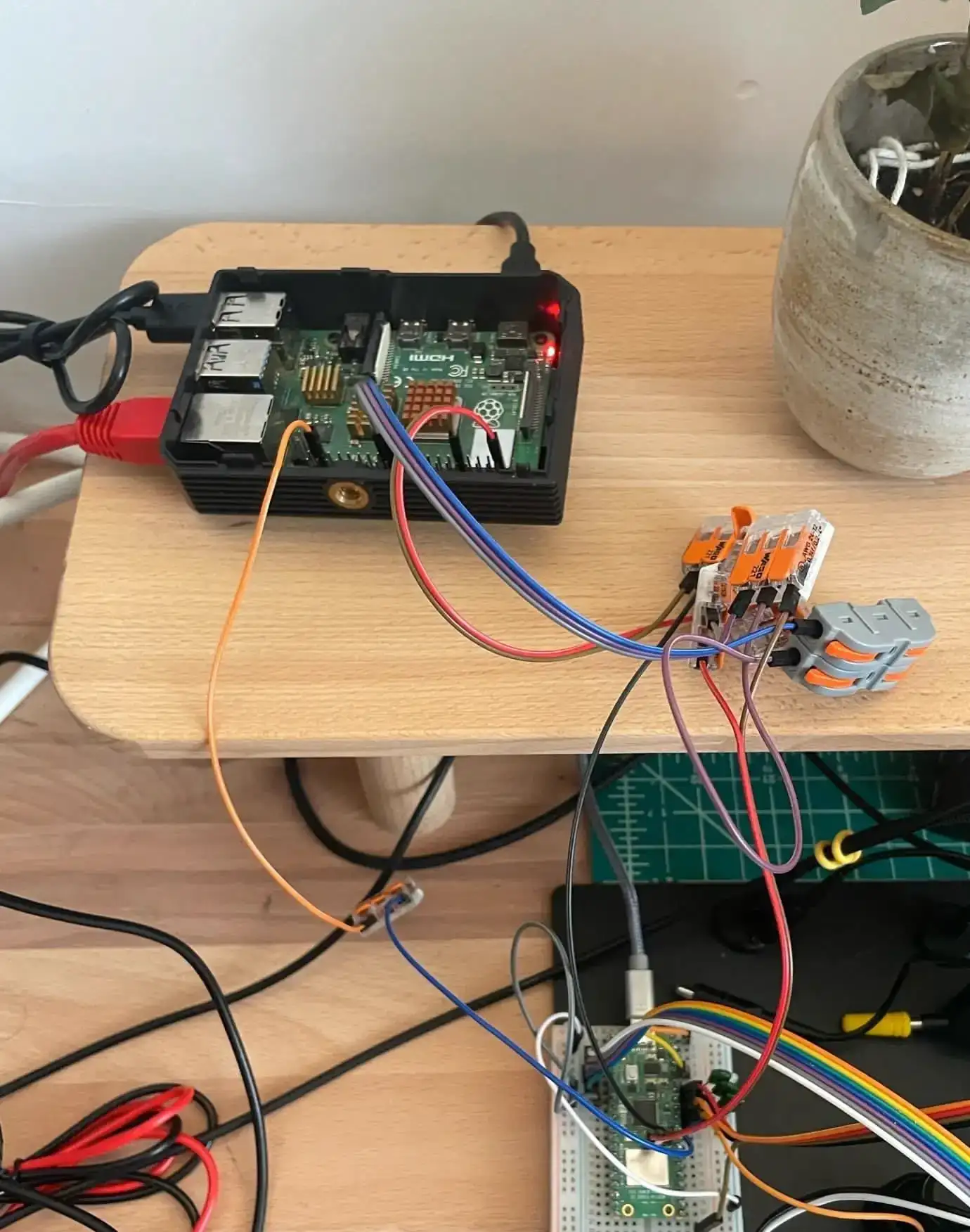 A Raspberry Pi 4b with a mess of wires connecting it to an rp2350 microcontroller